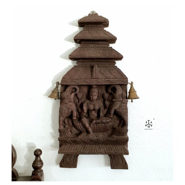 Kaavadi carved wood panel features Gajalakshmi